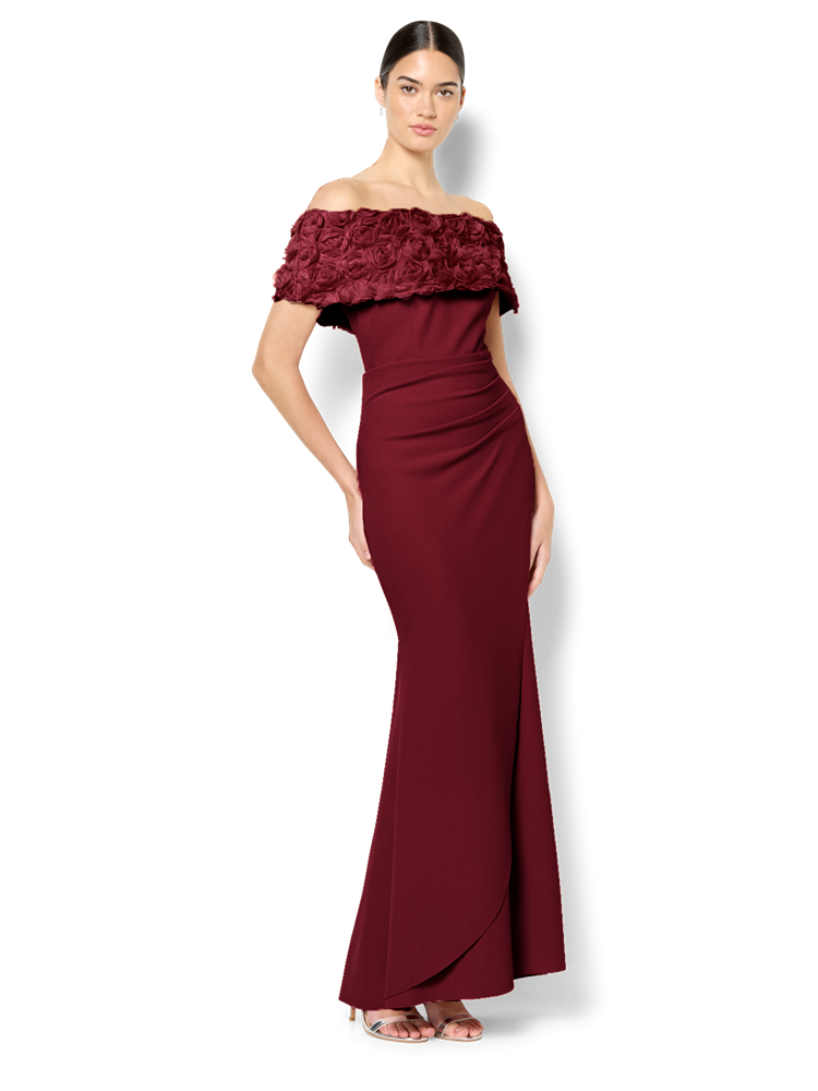 Woman wearing a burgundy off-shoulder gown with lace detailing on a white background