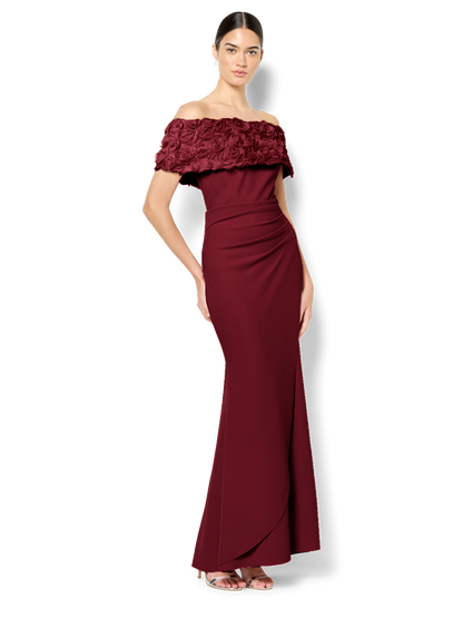 Woman wearing a burgundy off-shoulder gown with lace detailing on a white background